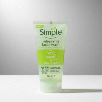 A transparent squeeze tube of Simple refreshing facial wash stands upright on a white surface. The tube has a green label with the brand logo and text that reads "Simple refreshing facial wash." The packaging also highlights that the product contains "VITAMIN B5+E" and is "100% SOAP FREE" and "PETA" certified.