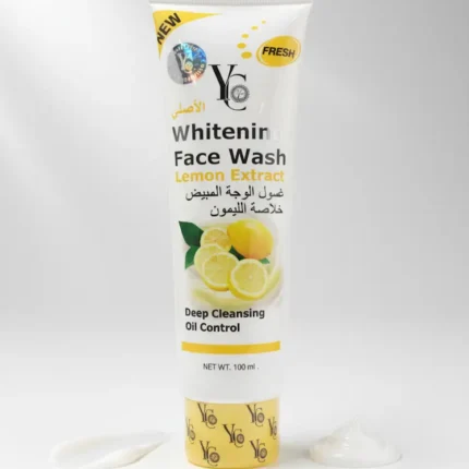 A white and black plastic squeeze tube of "Whitening Face Wash Milk Extract" is shown standing upright on a white surface. A small dollop of the white face wash is squeezed out and placed next to the tube. The packaging features a cartoon cow face with green eyes and a black and white cow print pattern. The text on the tube is in both English and Arabic. The product is labeled "NEW," "Milk," and "Y&G." It is also described as "Deep Cleaning, Moisturizing & pH-Balance" and "NET WT. 190 ml.